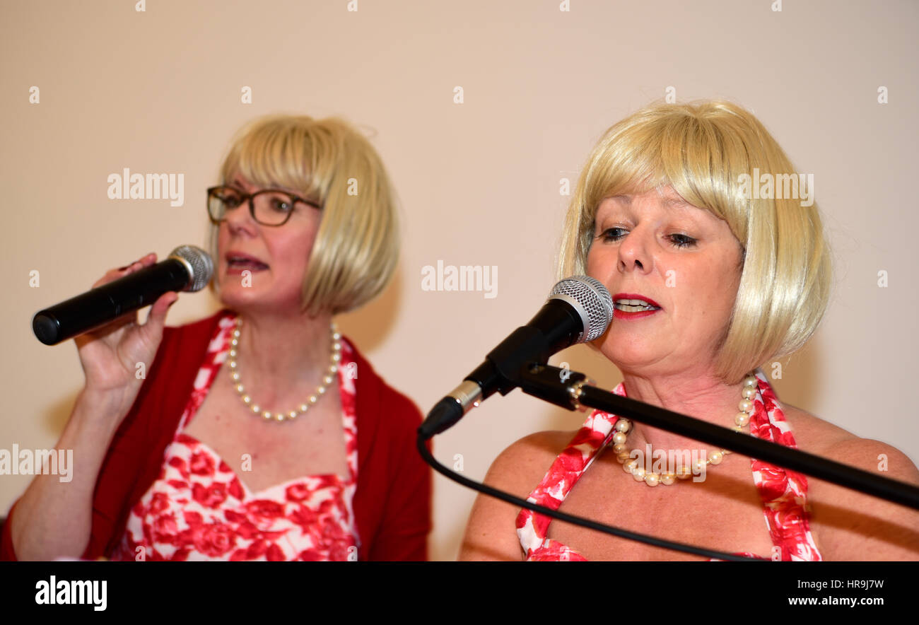 Chanteuses de groupe local - de l'ombre - l'exécution de chansons populaires de la communauté des années 60, à une manifestation organisée par le conseil municipal local Banque D'Images