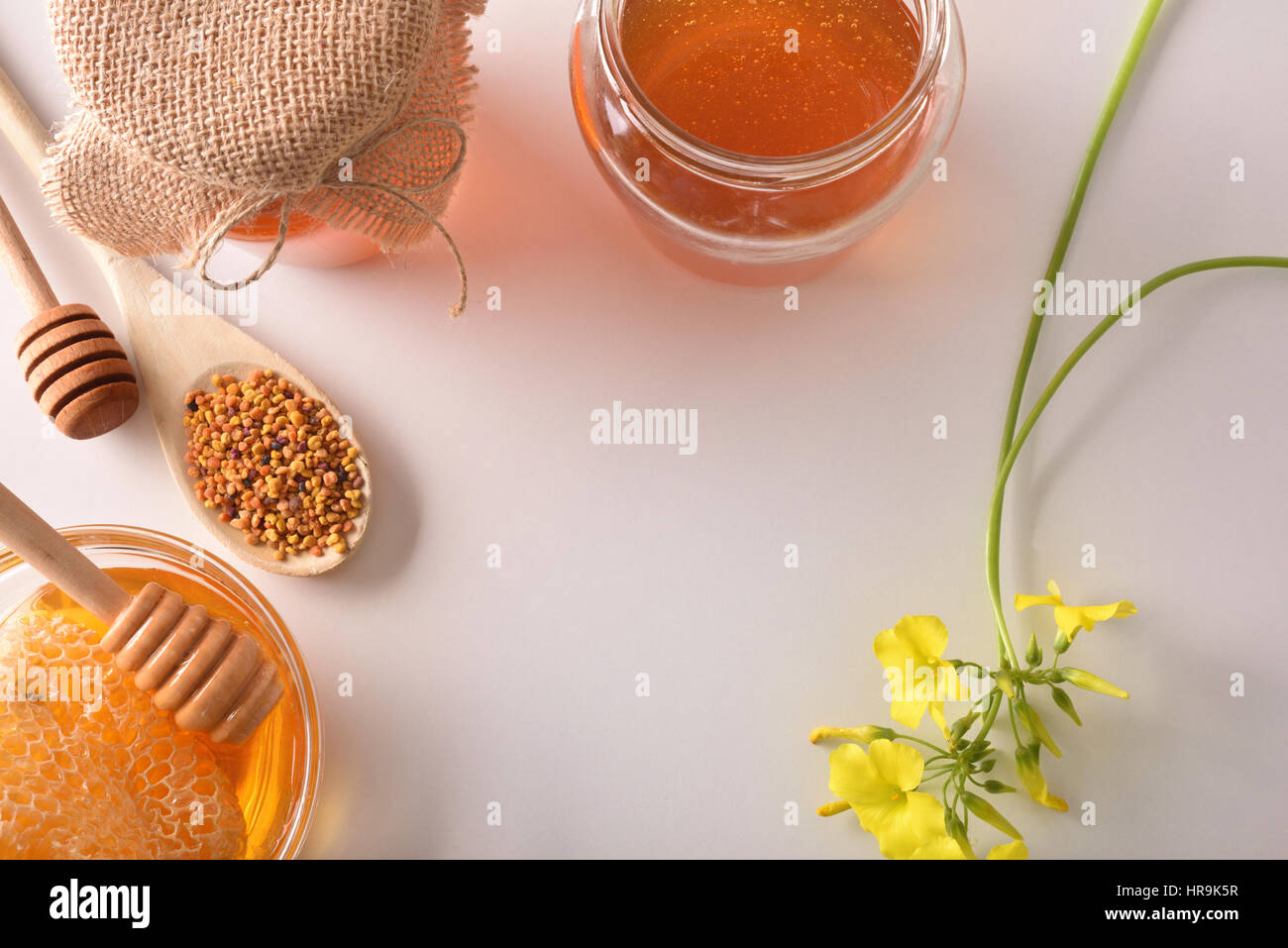 Les contenants avec du miel, pollen et en nid d'abeille. Décoration avec des fleurs et des grains de pollen. Vue d'en haut. Composition horizontale Banque D'Images