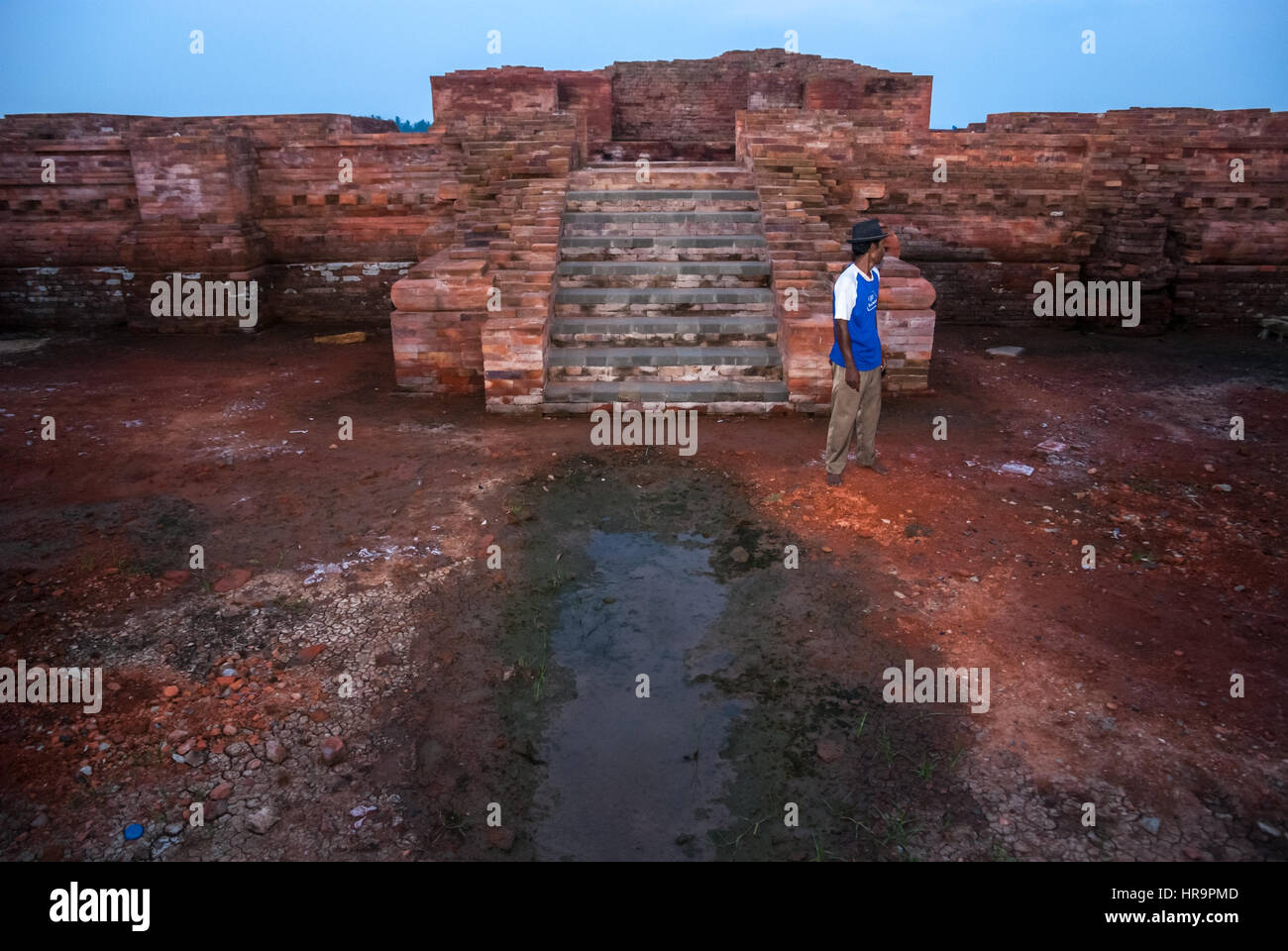 Un homme local se tient devant l'ancien temple Blandongan à Batujaya, dans l'ouest de Java, à la tombée de la nuit. Banque D'Images