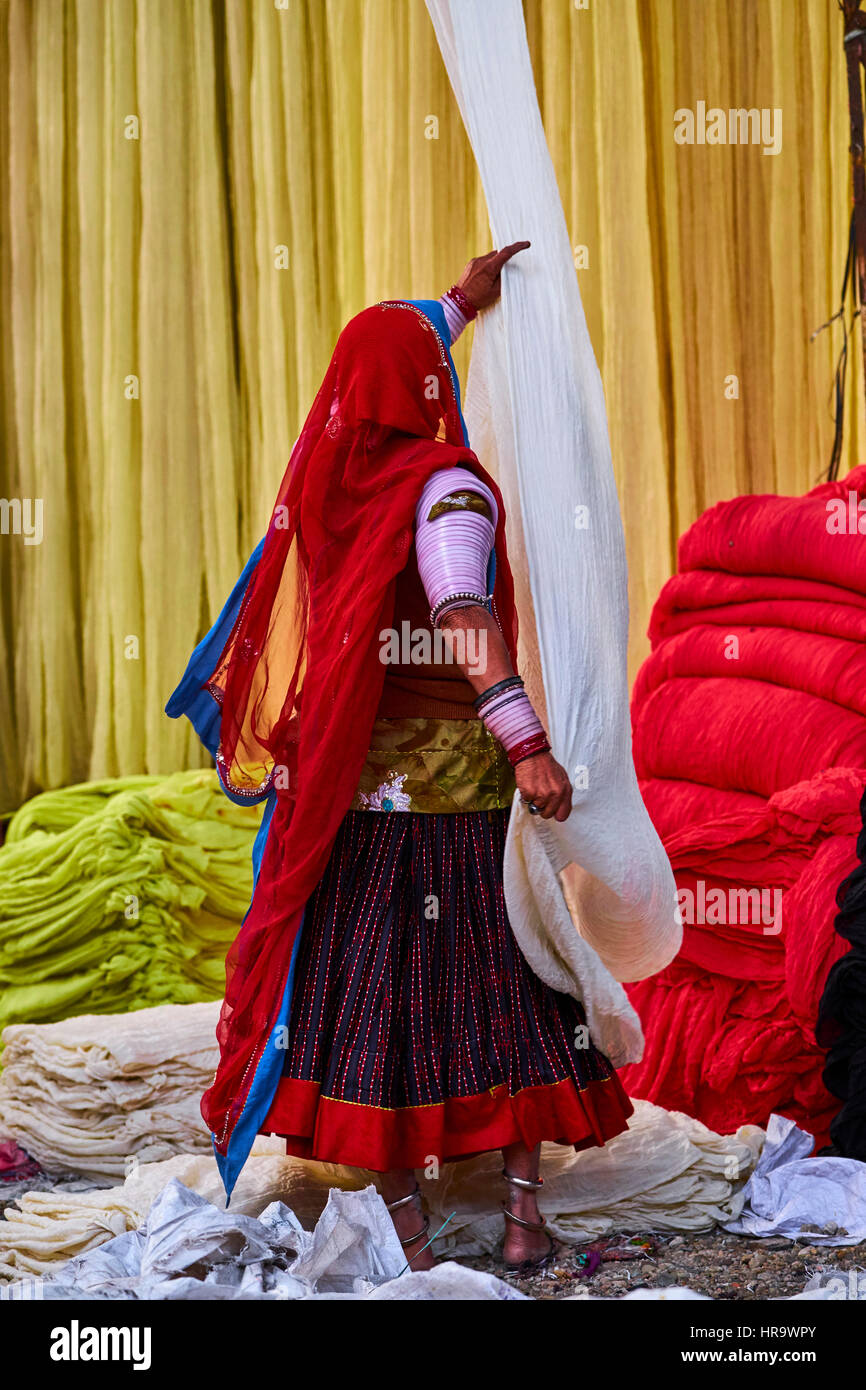 L'Inde, Rajasthan, Sari, usine textile sont séchés à l'air libre. La collecte des textiles à sec sont pliées par les femmes. Les tissus sont suspendus pour le séchage sur bamb Banque D'Images