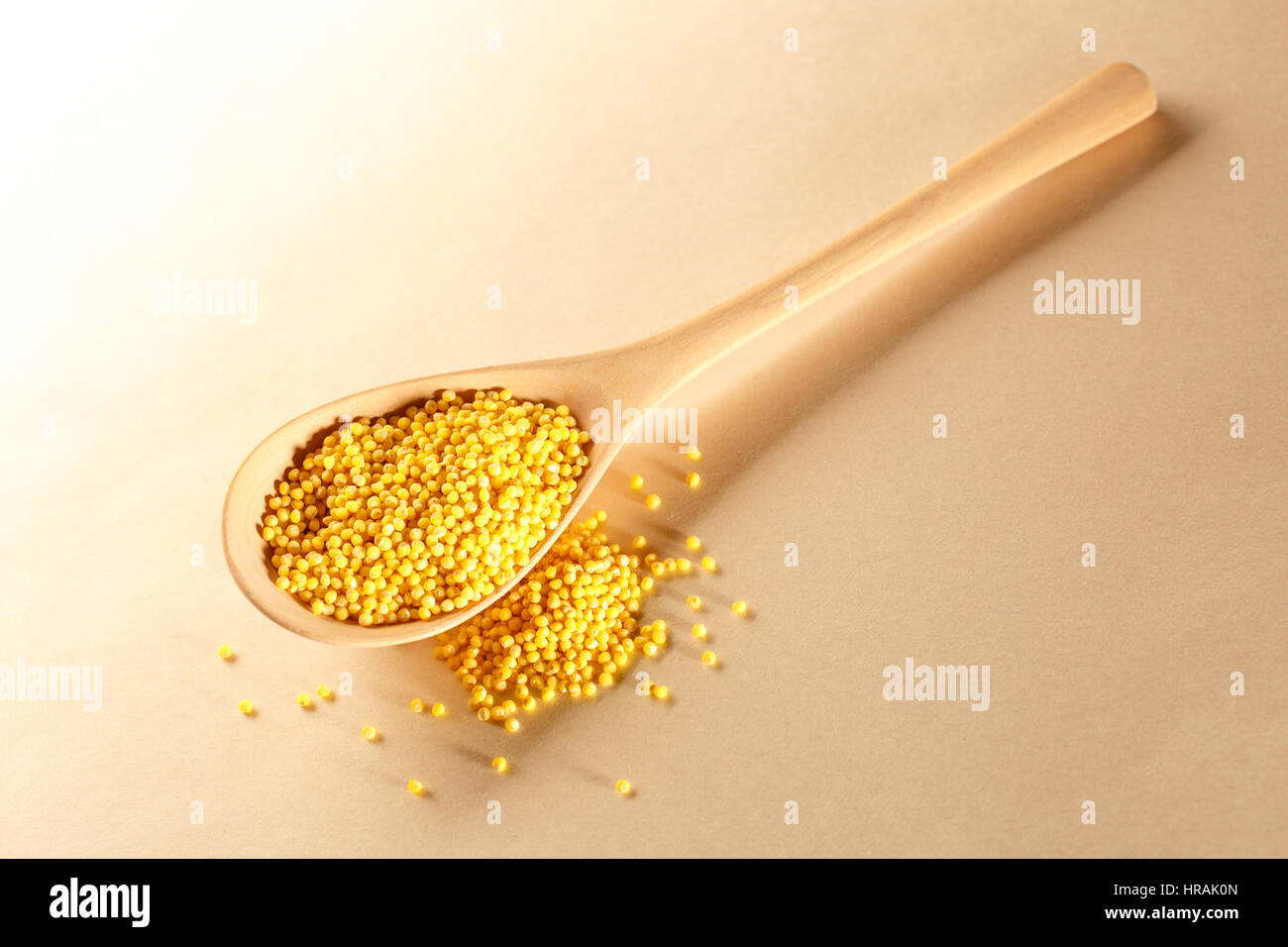 Gruau de millet avec cuillère de bois sur papier Banque D'Images