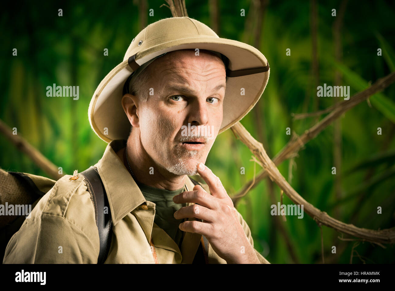 Aventurier dans la jungle rétro thinking with hand on chin. Banque D'Images Aventurier dans la jungle rétro thinking with hand on chin. Banque D'Images
