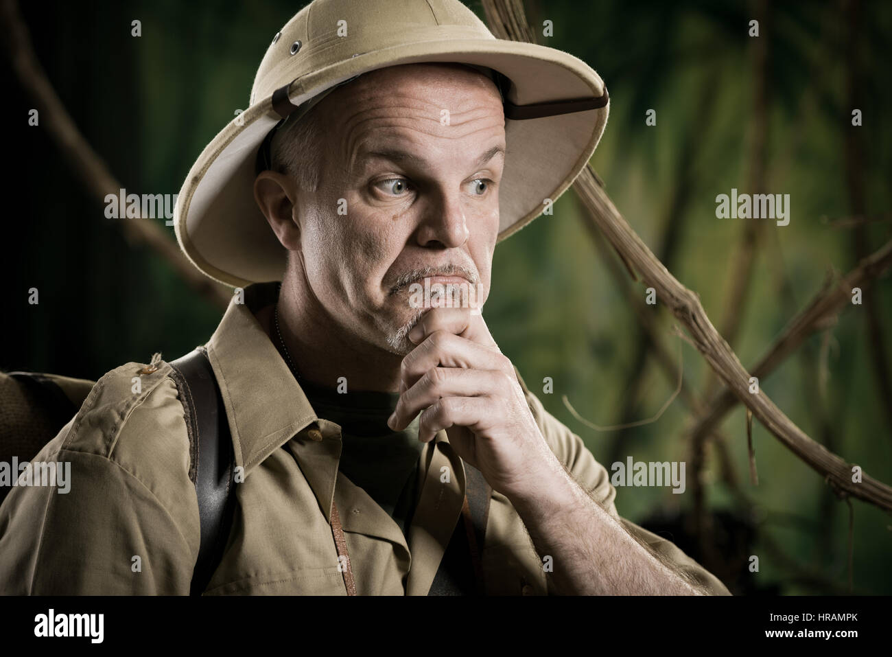 Aventurier dans la jungle rétro thinking with hand on chin. Banque D'Images Aventurier dans la jungle rétro thinking with hand on chin. Banque D'Images