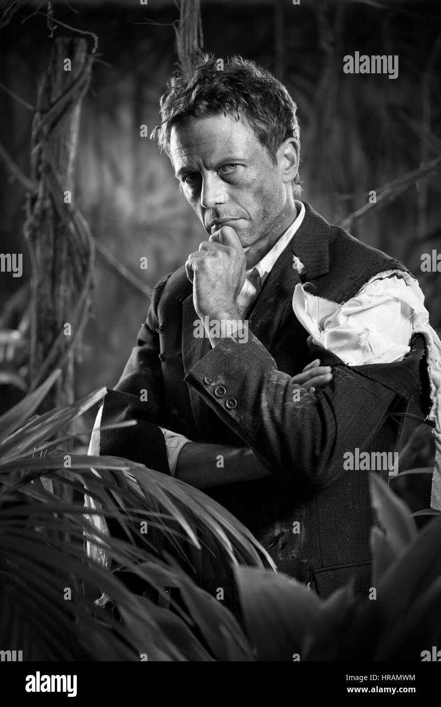 Businessman perdu dans la pensée de la jungle en toute confiance avec la main sur le menton. Banque D'Images Businessman perdu dans la pensée de la jungle en toute confiance avec la main sur le menton. Banque D'Images