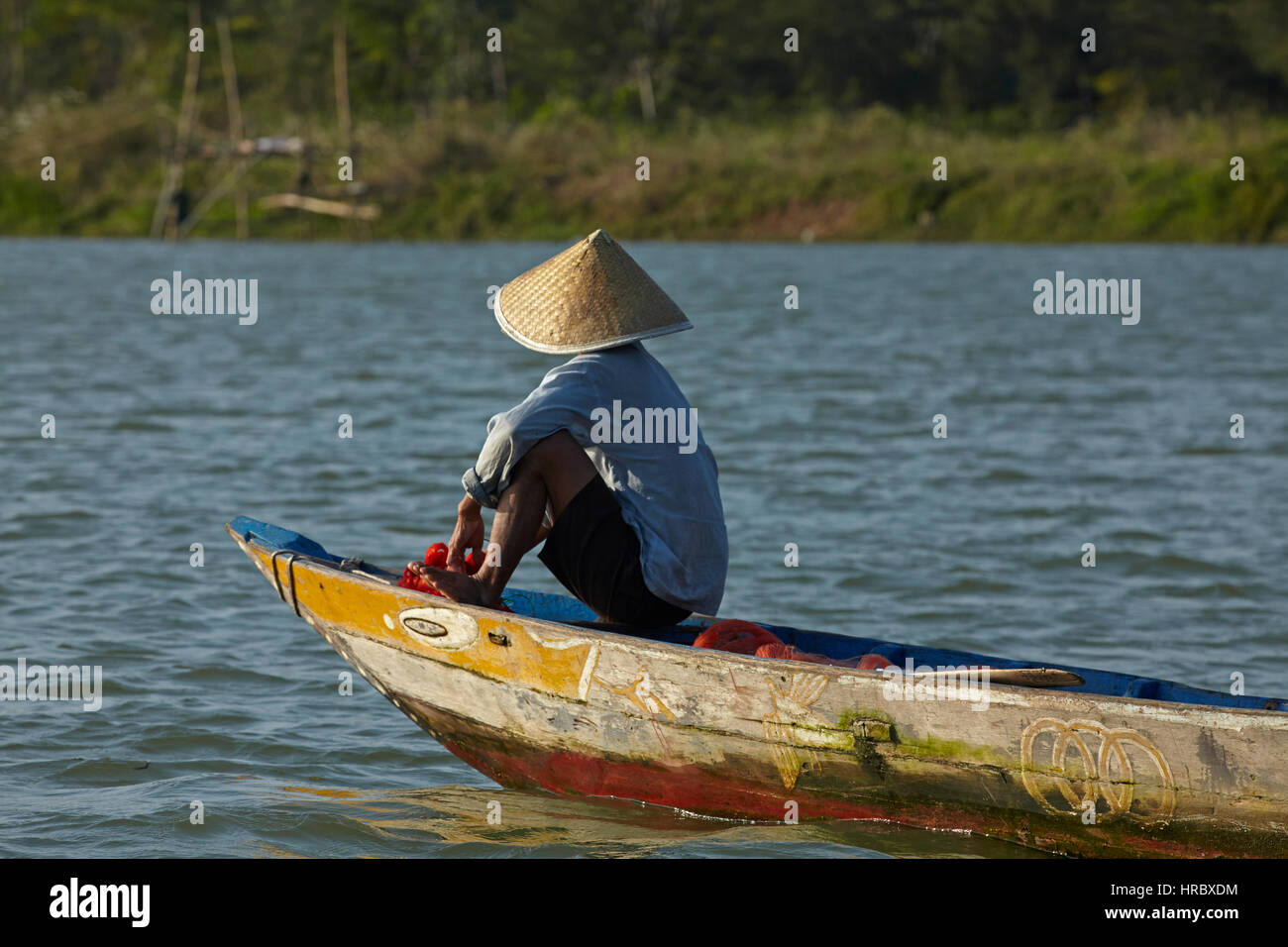Bateau de pêche l'homme sur la rivière Thu Bon, Hoi An (Site du patrimoine mondial de l'UNESCO), Vietnam Banque D'Images