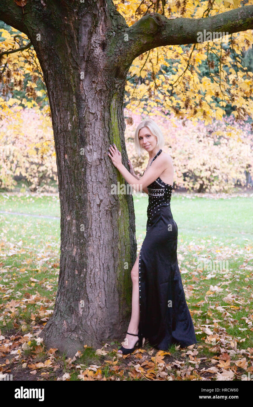 Belle femme blanche posant dans la nature en plein air avec des arbres et des fleurs Banque D'Images