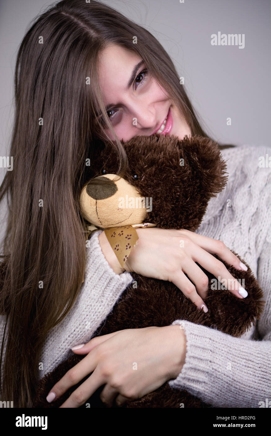 Belle brune femme avec son ours en peluche. Effets de couleurs et de balance des blancs personnalisée sont utilisés sur cette photo. Banque D'Images