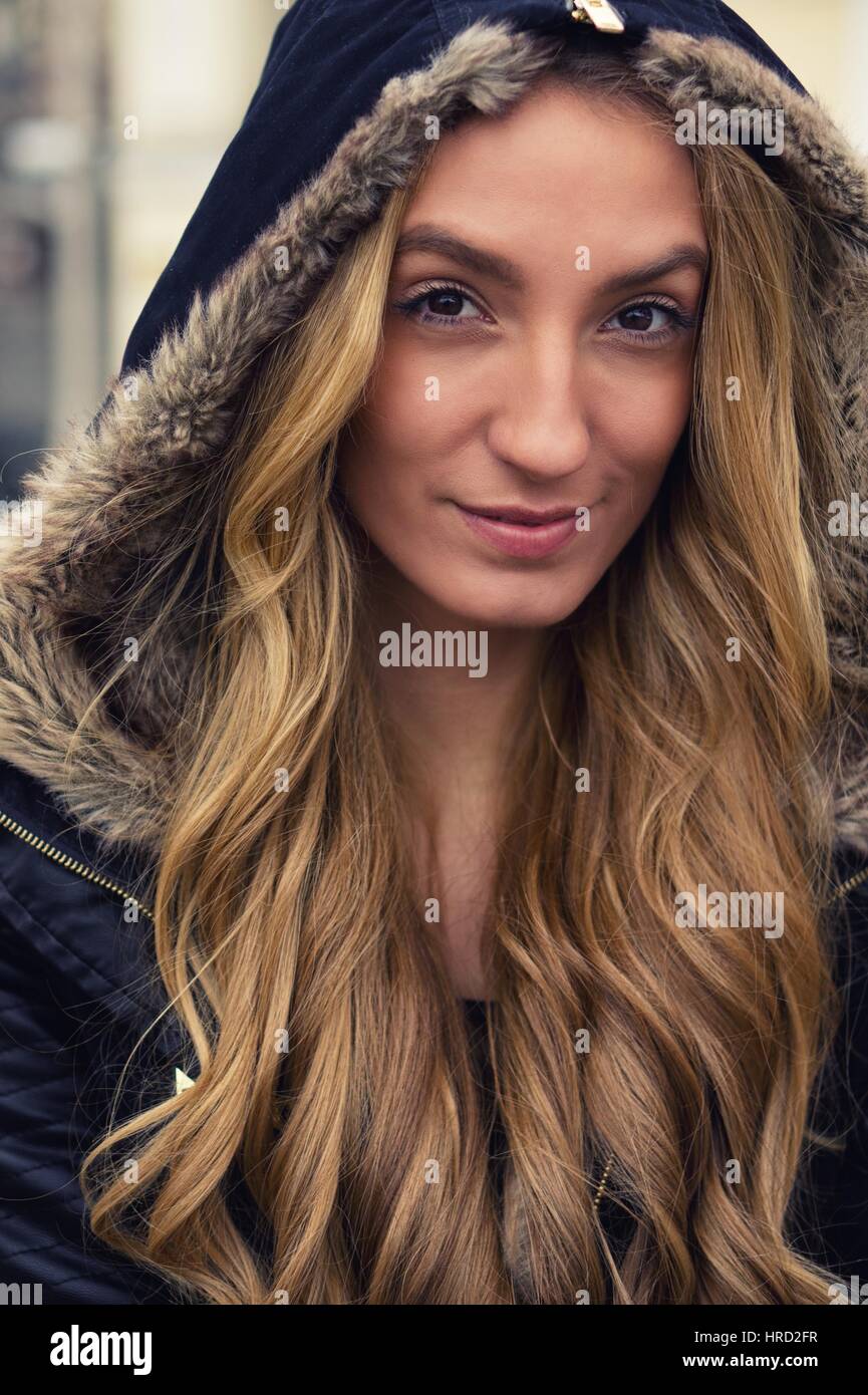 Belle blonde femme dans un manteau noir. Effets de couleurs et de balance des blancs personnalisée sont utilisés sur cette photo. Banque D'Images