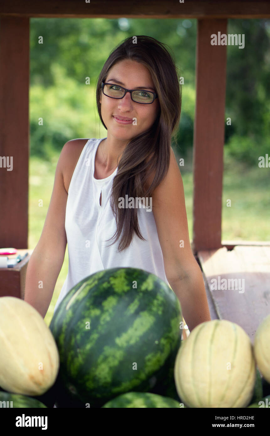 Jolie jeune femme vendant du melon Banque D'Images