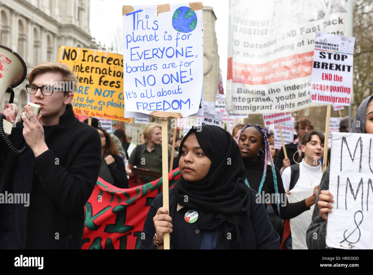 Une jeune étudiante musulmane manifestant est holding a placard lecture : "Cette planète est pour tout le monde, les frontières sont pour PERSONNE ! Il est tout au sujet de la liberté Banque D'Images