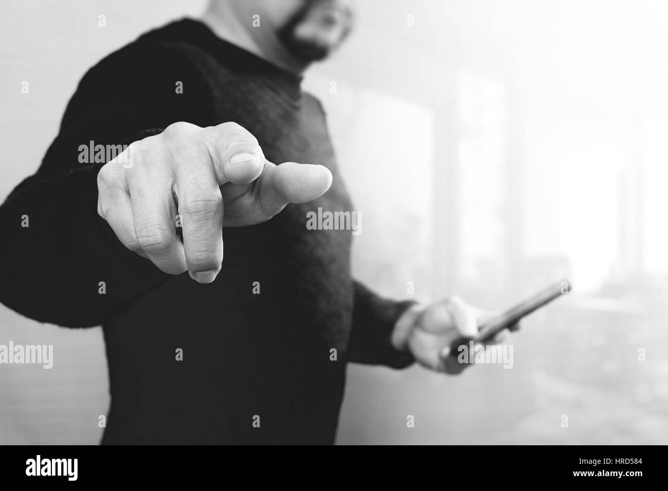 Businessman hand en appuyant sur un bouton imaginaire,holding smart phone,écran numérique vide virtuel graphique graphique icônes,schéma,Black,white Banque D'Images