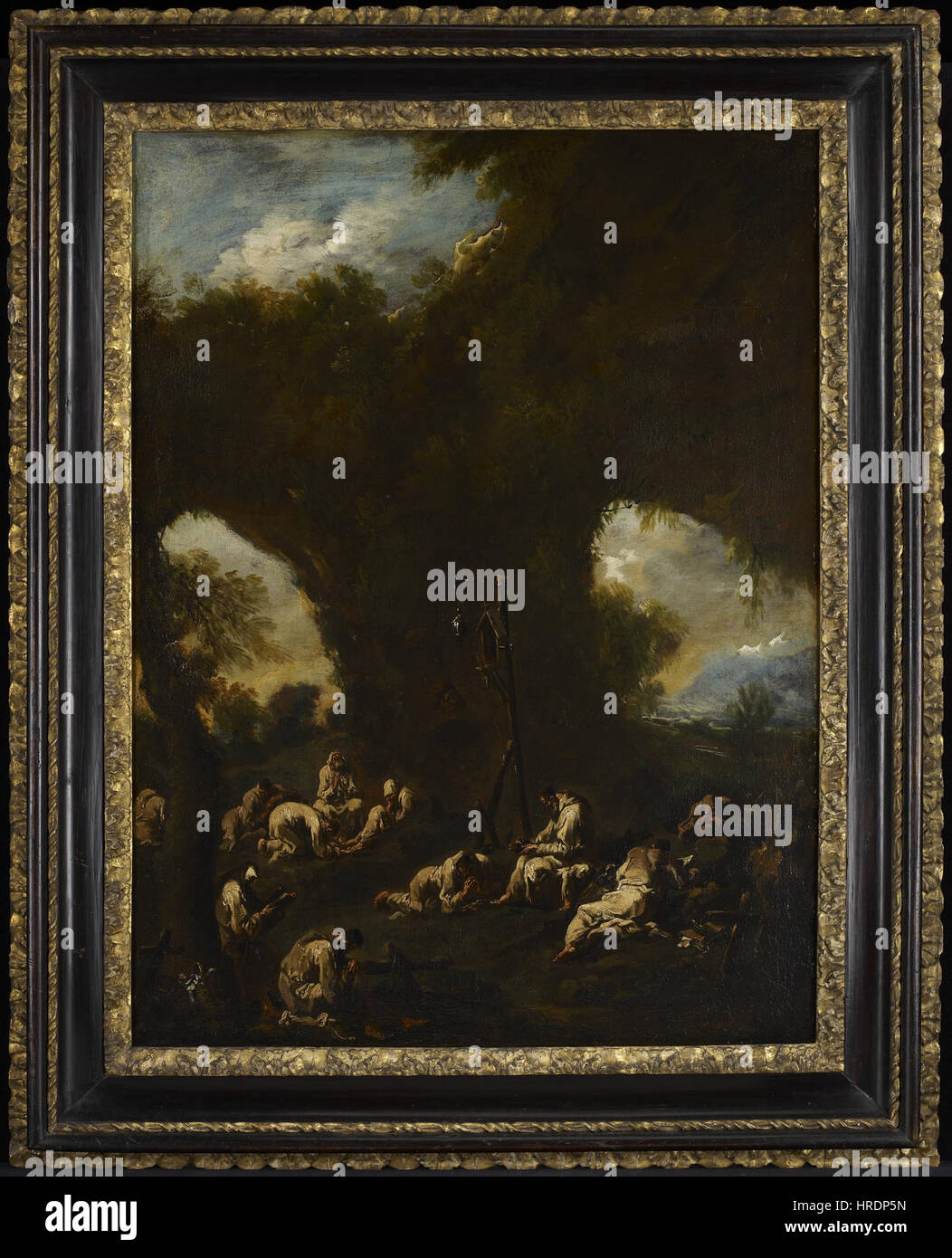 'Moines priant dans une grotte' d'Alessandro Magnasco et Antonio Francesco Peruzzini montre un groupe de moines engagés dans la prière à l'intérieur d'une grotte. La pièce capte la solennité et l’atmosphère spirituelle du moment. Banque D'Images