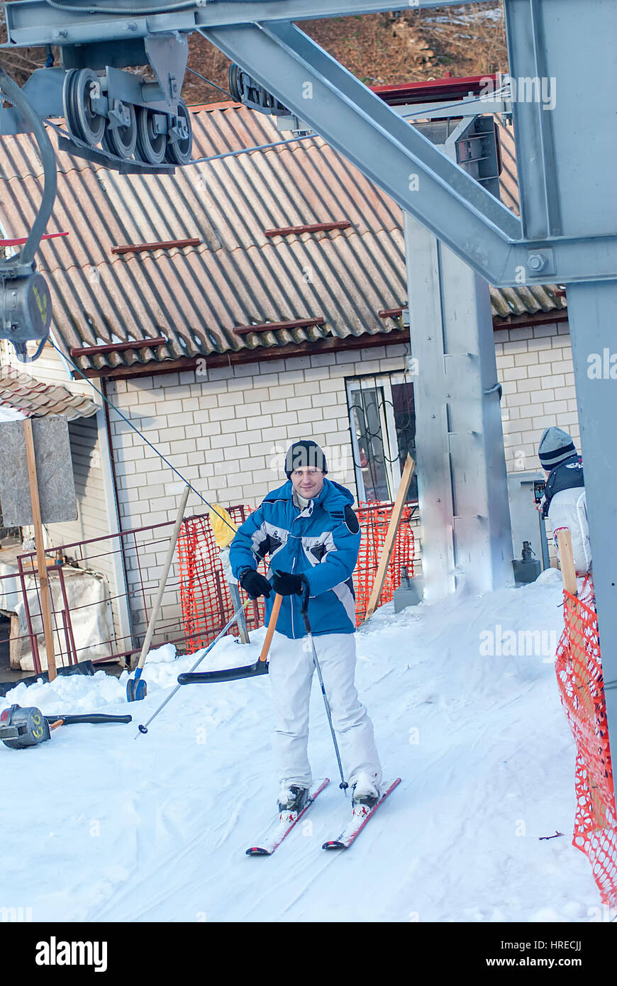 Jeune homme en veste avec ski et ascenseur Banque D'Images