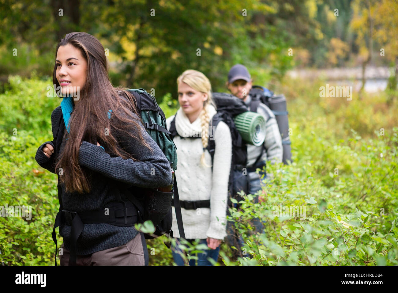 Belle jeune femme avec des amis au milieu de la marche en forêt plantes Banque D'Images