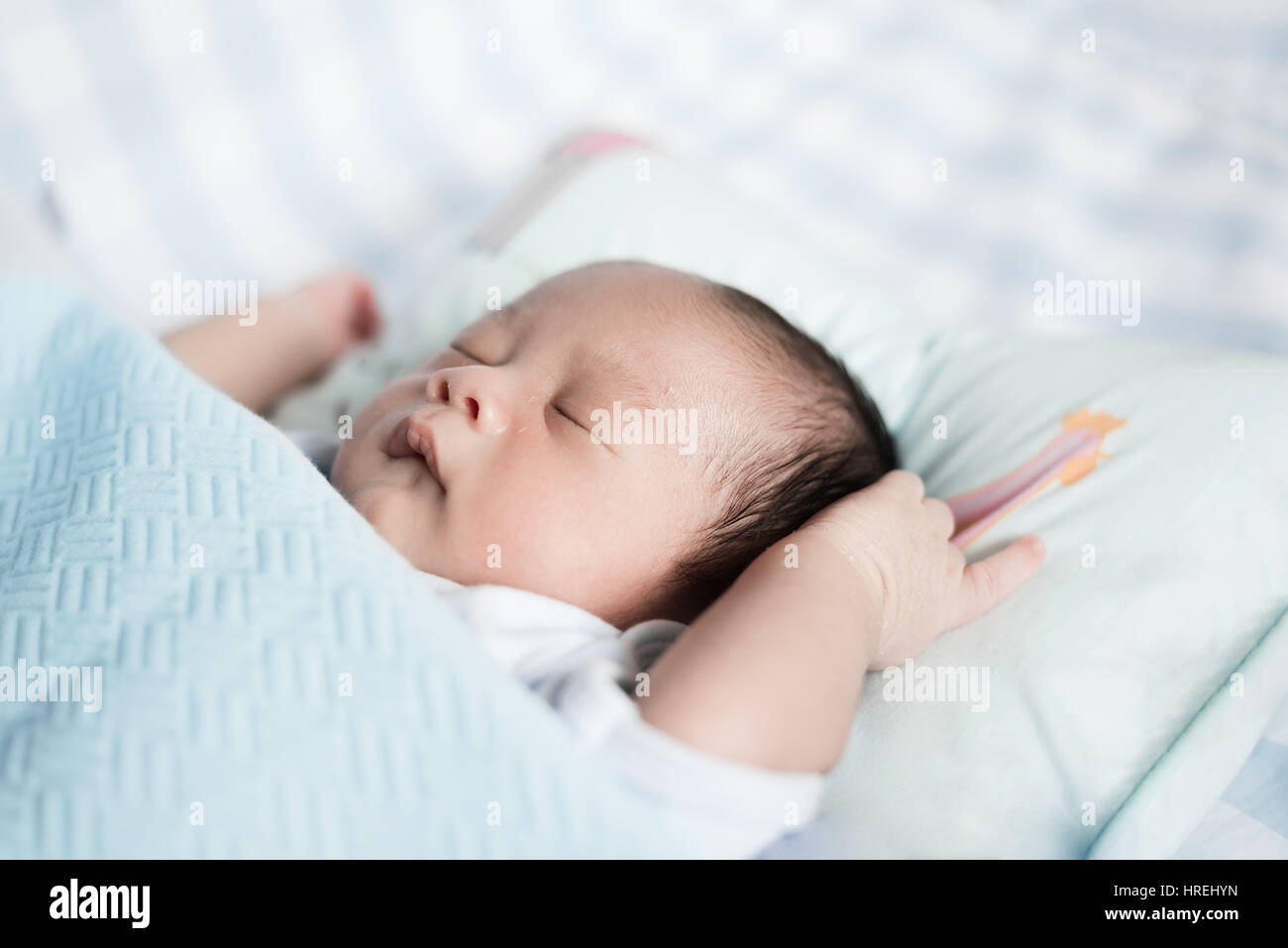 Bébé garçon asiatique dormir dans une couverture bleue au lit. 1 mois bébé garçon. Banque D'Images