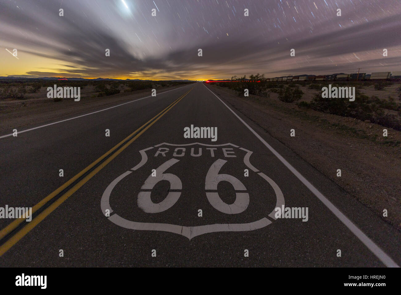 L'historique Route 66 chaussée sur signer tard dans la nuit dans le désert de Mojave en Californie. Banque D'Images