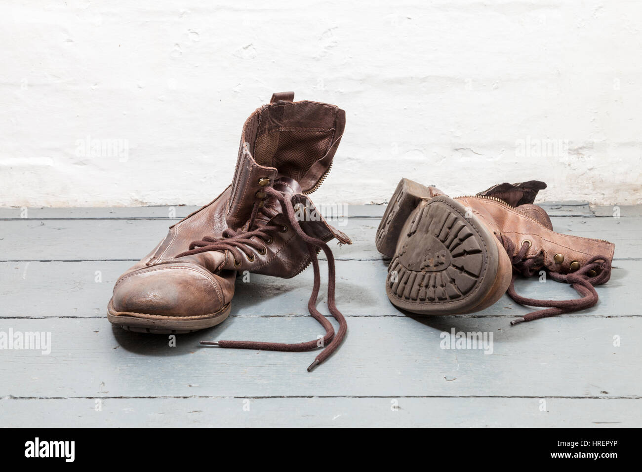 Une vieille paire de bottes en cuir marron à gauche sur les planches Banque D'Images