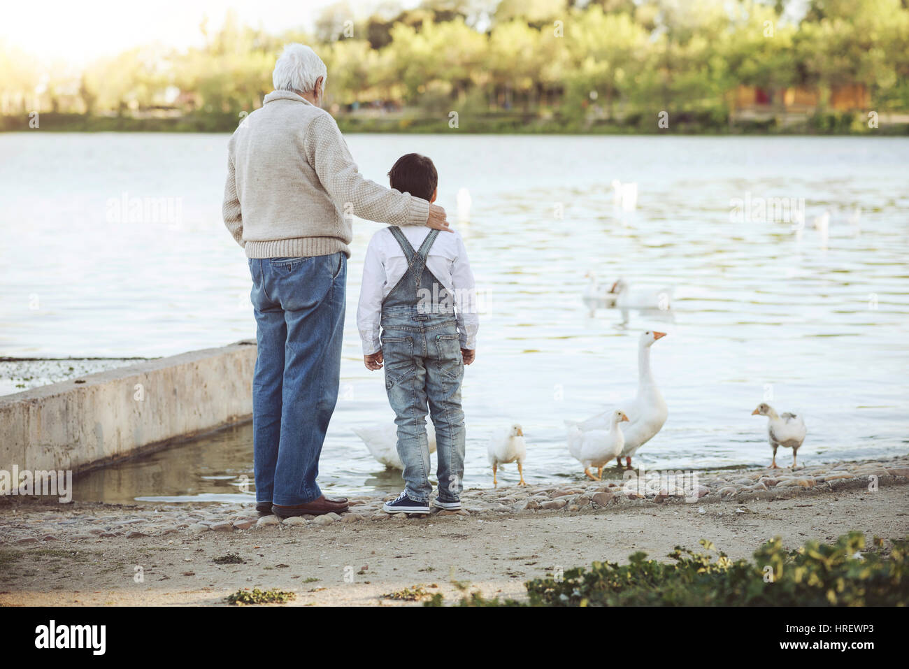 Grand-père avec son petit-fils sur le lac. Vue arrière Banque D'Images