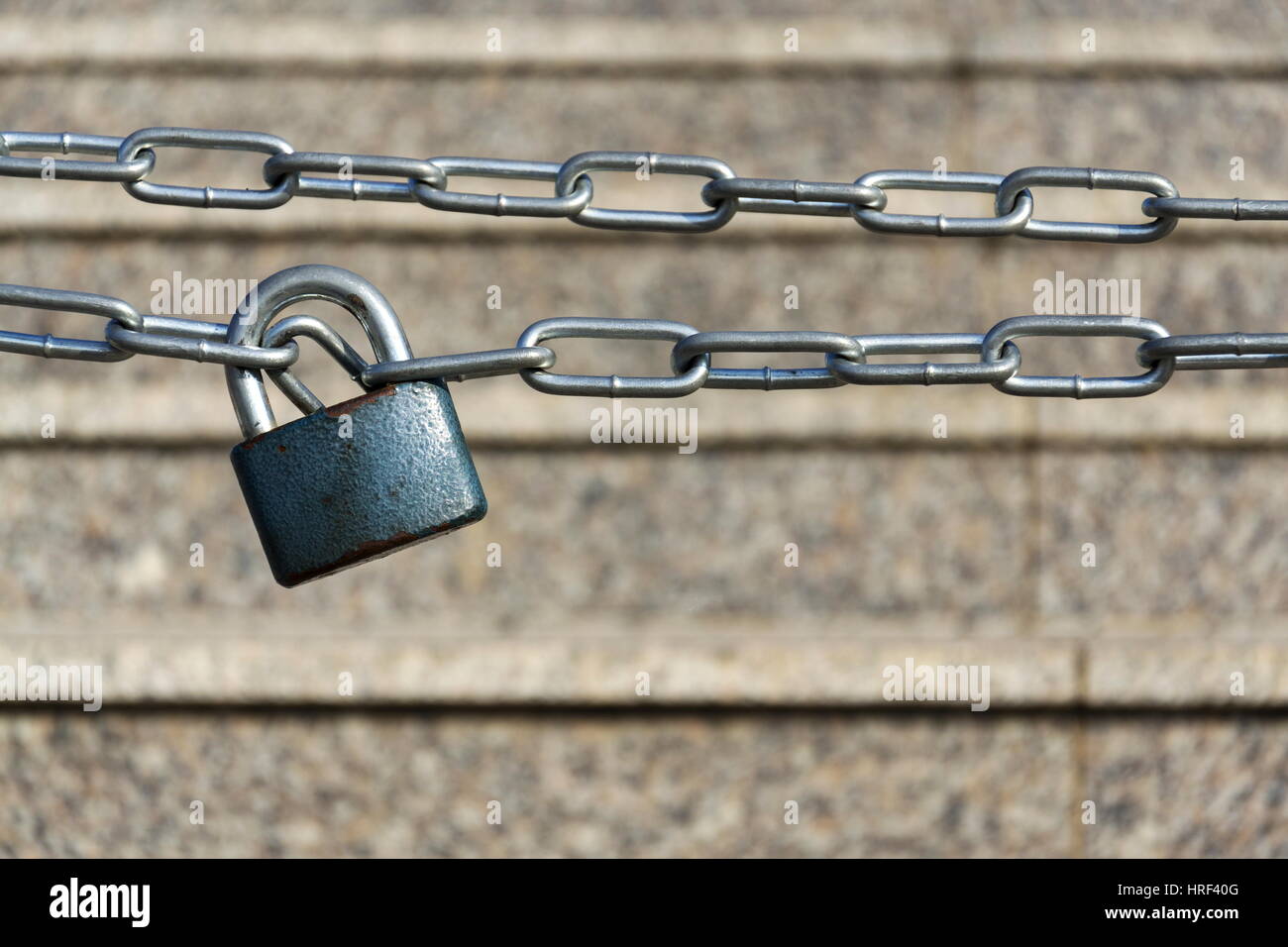 Cadenas bleu métallique est suspendu sur la chaîne de fer d'argent avec des escaliers Banque D'Images