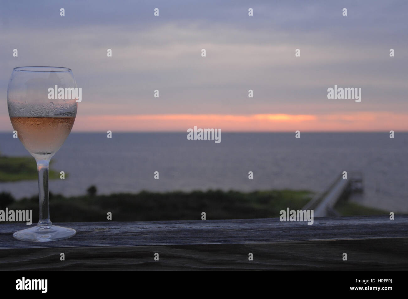 Verre à vin sur le pont au coucher du soleil Pamlico Sound, Outer Banks, Caroline du Nord. Banque D'Images
