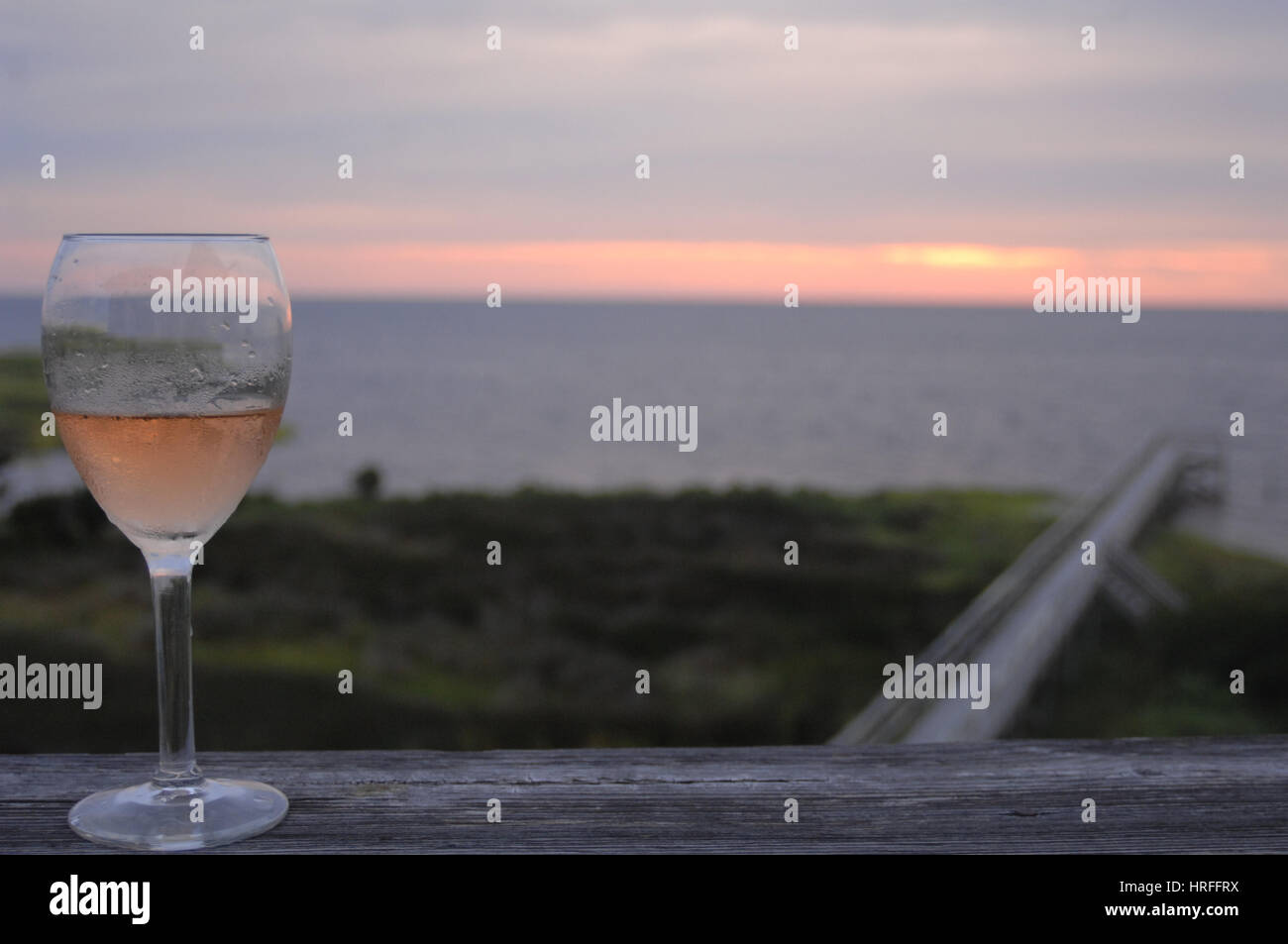 Verre à vin sur le pont au coucher du soleil Pamlico Sound, Outer Banks, Caroline du Nord. Banque D'Images