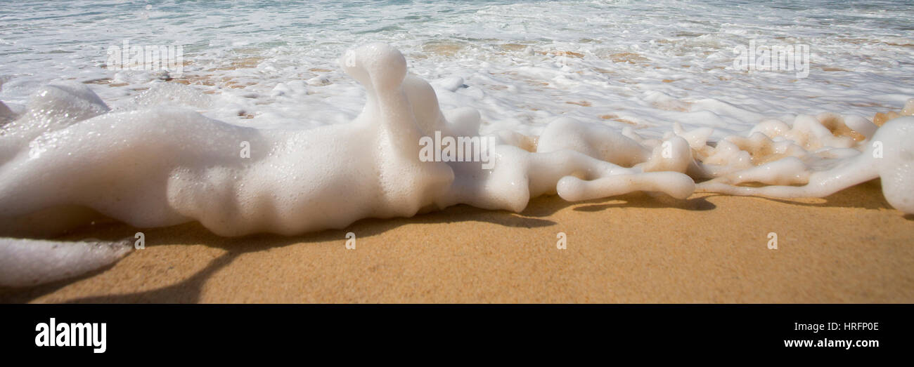 Une vague mousseuse travailler c'est manière d'une plage Australienne Banque D'Images