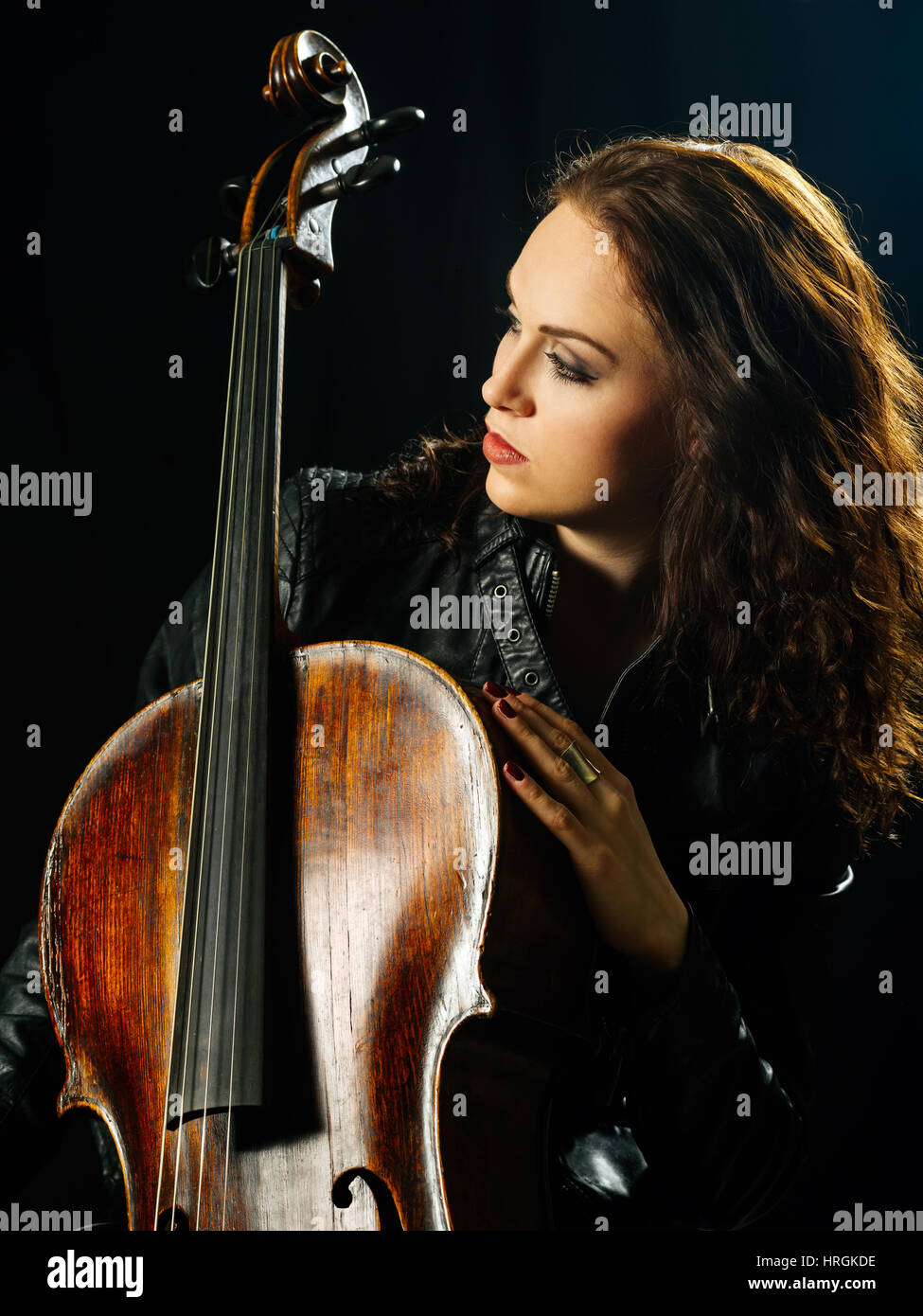 Photo d'une belle femme posant avec son vieux violoncelle. Banque D'Images