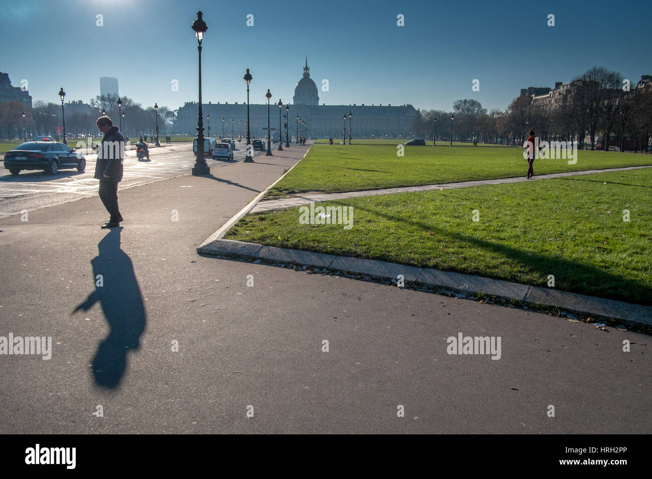 Personne phone jette un long hiver ombre portée avec les invalides dans l'arrière-plan, Paris, France. Banque D'Images