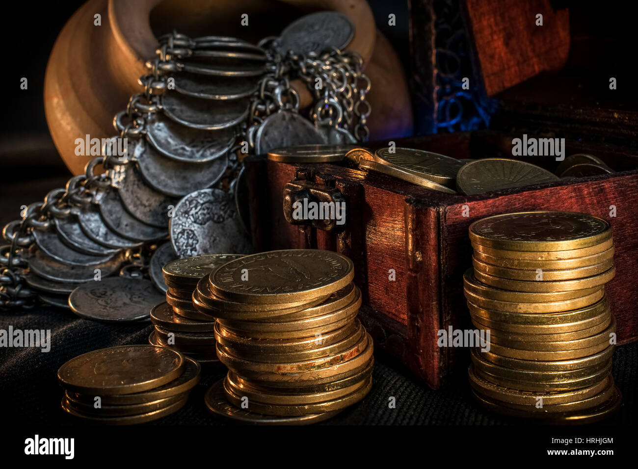 Coffre à Trésor, pieu et pilier de pièces en céramique, un bol rempli de pièces de monnaie et bijoux lampe bougie dans l'obscurité Banque D'Images