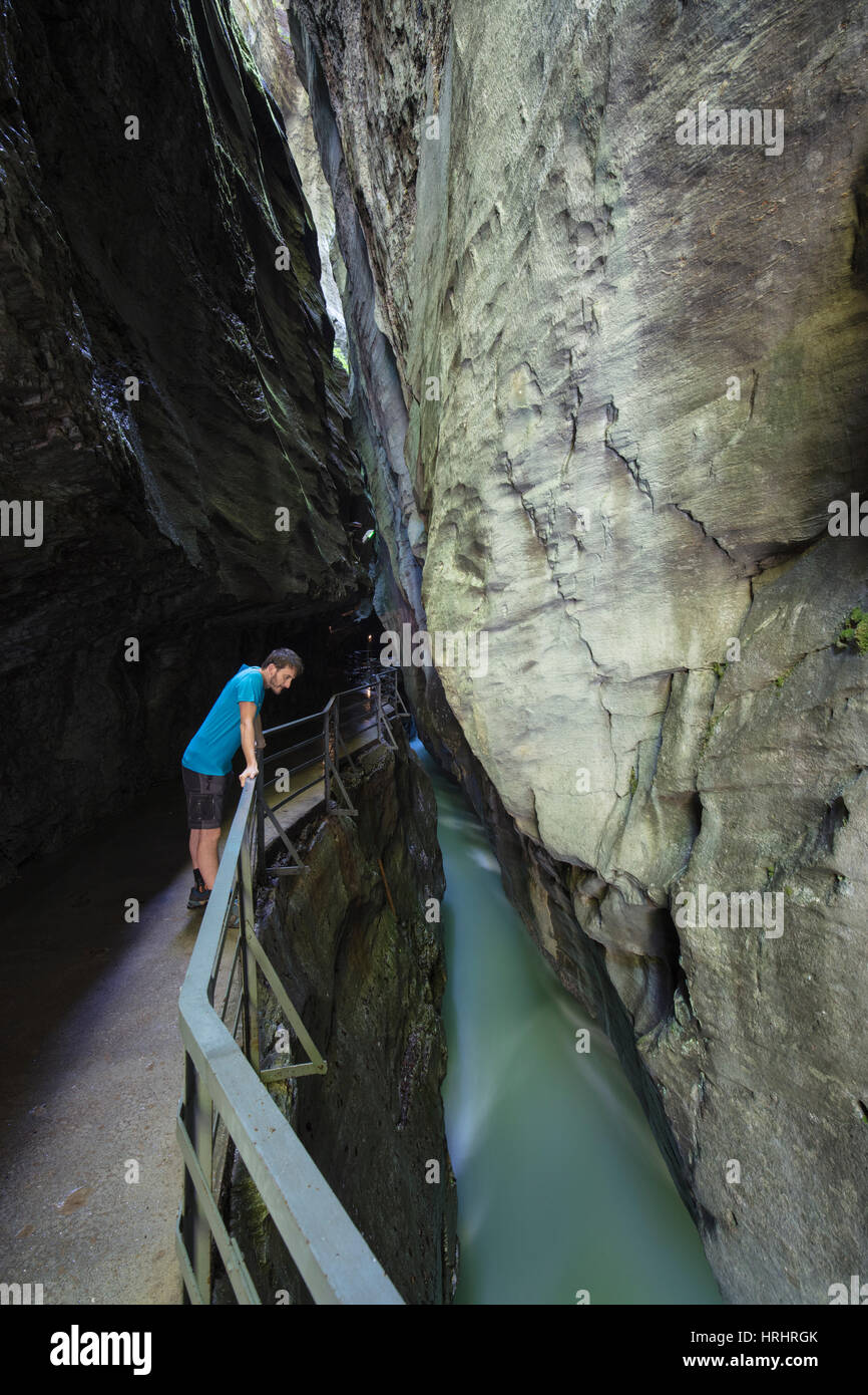 Randonneur sur walkway admire le creek dans l'étroite gorge calcaire, Gorges de l'Aar, Oberland Bernois, Canton d'Uri, Suisse Banque D'Images