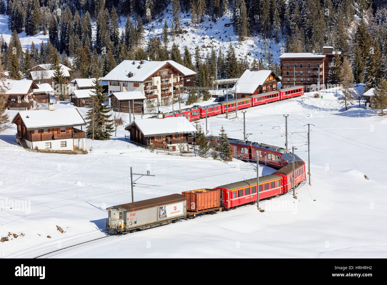 Train rouge du chemin de fer rhétique passe dans le paysage enneigé d'Arosa, district de Plessur, Canton des Grisons, Suisse Banque D'Images