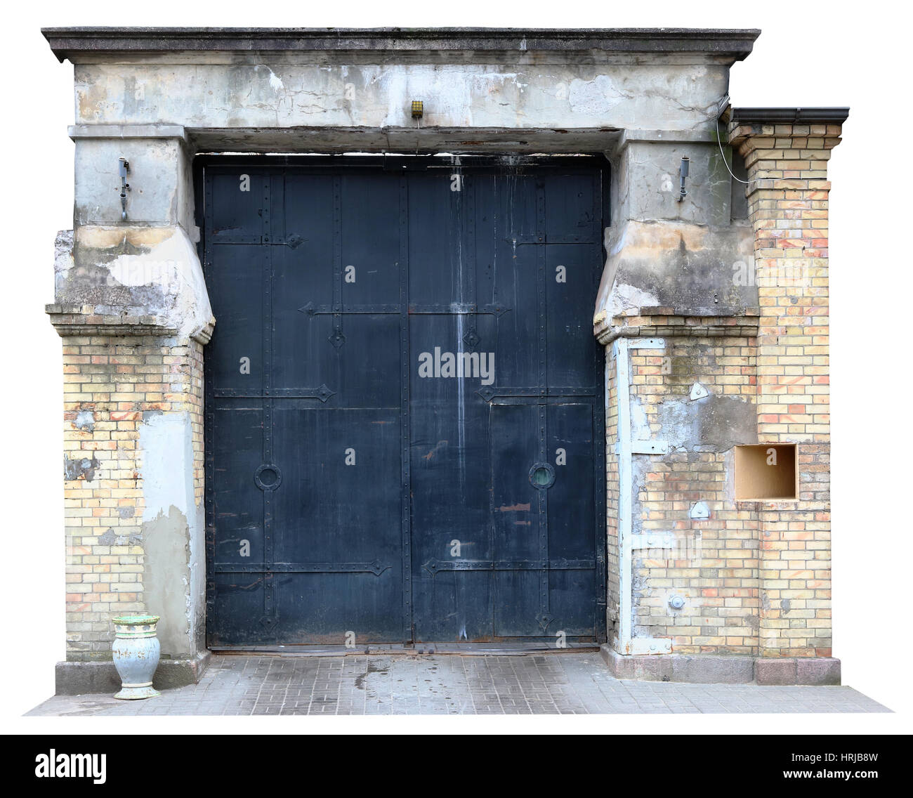 Prison Vintage âgés de porte de fer dans le mur de brique jaune en ruine. Fragment isolé Banque D'Images