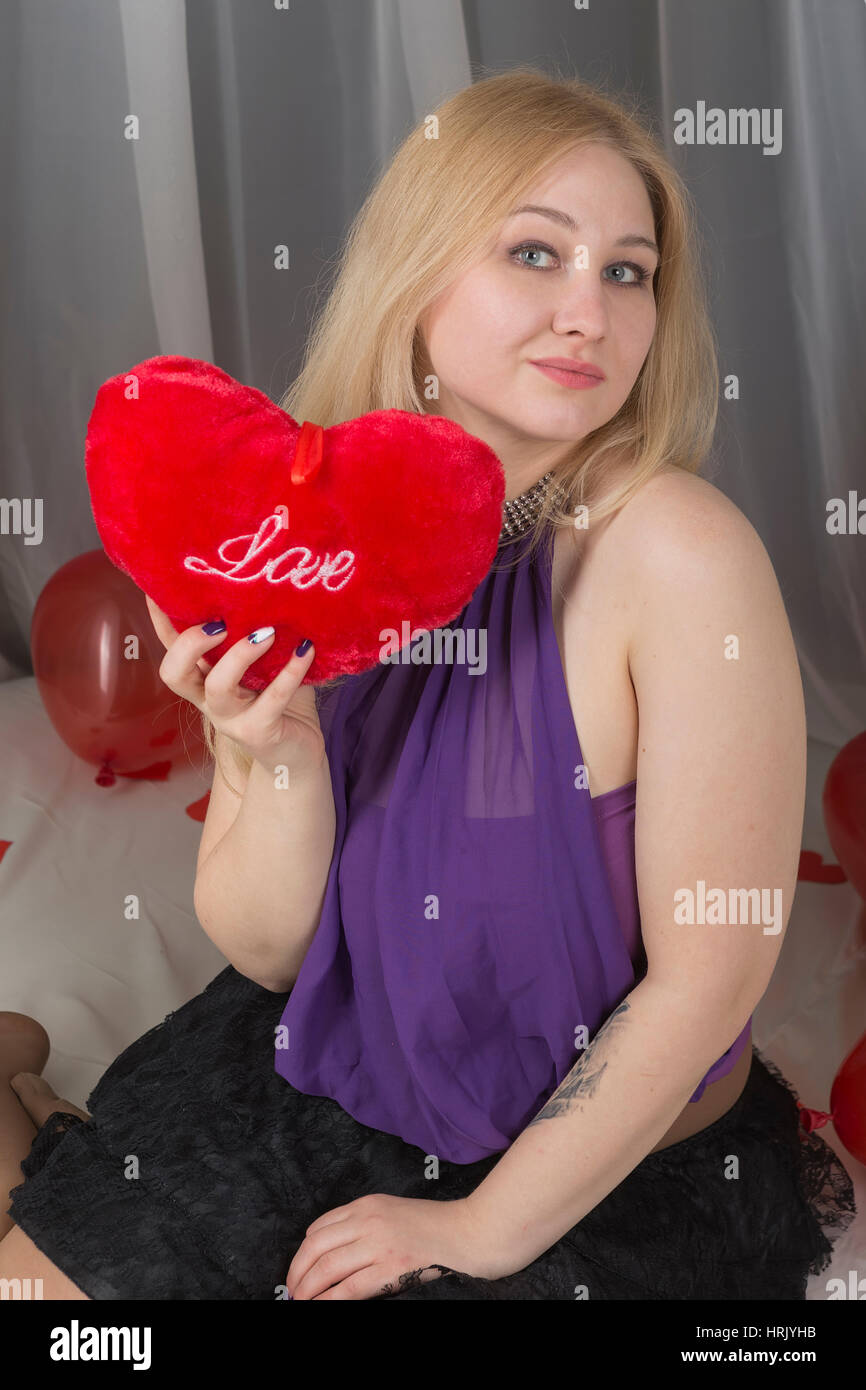 Jeune fille avec un symbole de l'amour le jour de la Saint-Valentin dans la chambre. Banque D'Images