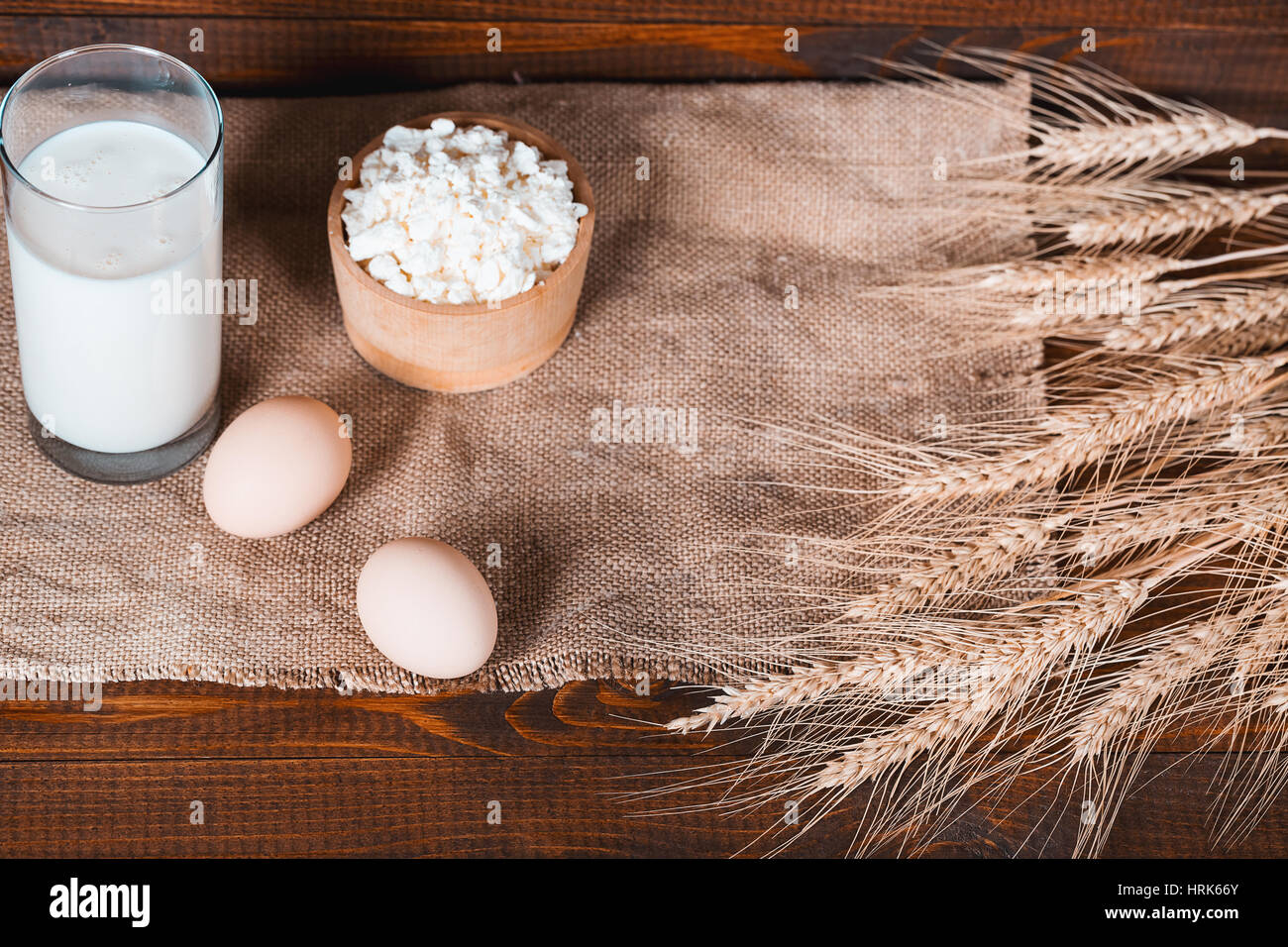 Les produits faits maison : le lait, le fromage, la crème et les oeufs sur le vieux fond de bois avec des épis de blé. Avec l'espace pour votre texte Banque D'Images
