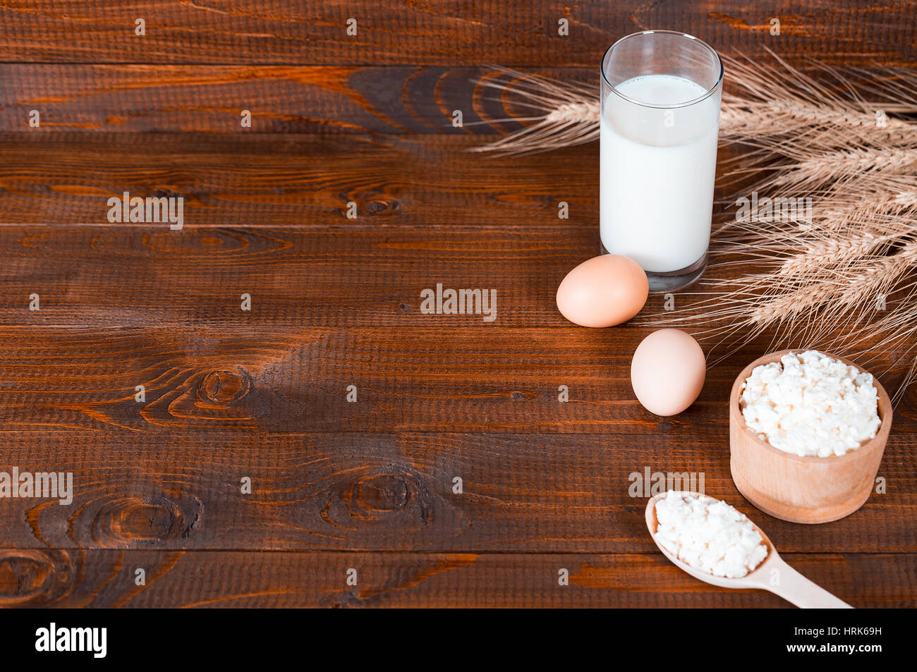 Les produits faits maison : le lait, le fromage, la crème et les oeufs sur le vieux fond de bois avec des épis de blé. Avec l'espace pour votre texte Banque D'Images