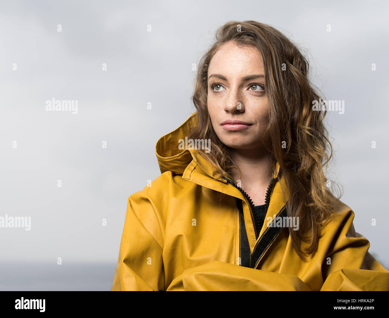Jeune femme en veste de pêche jaune Banque D'Images