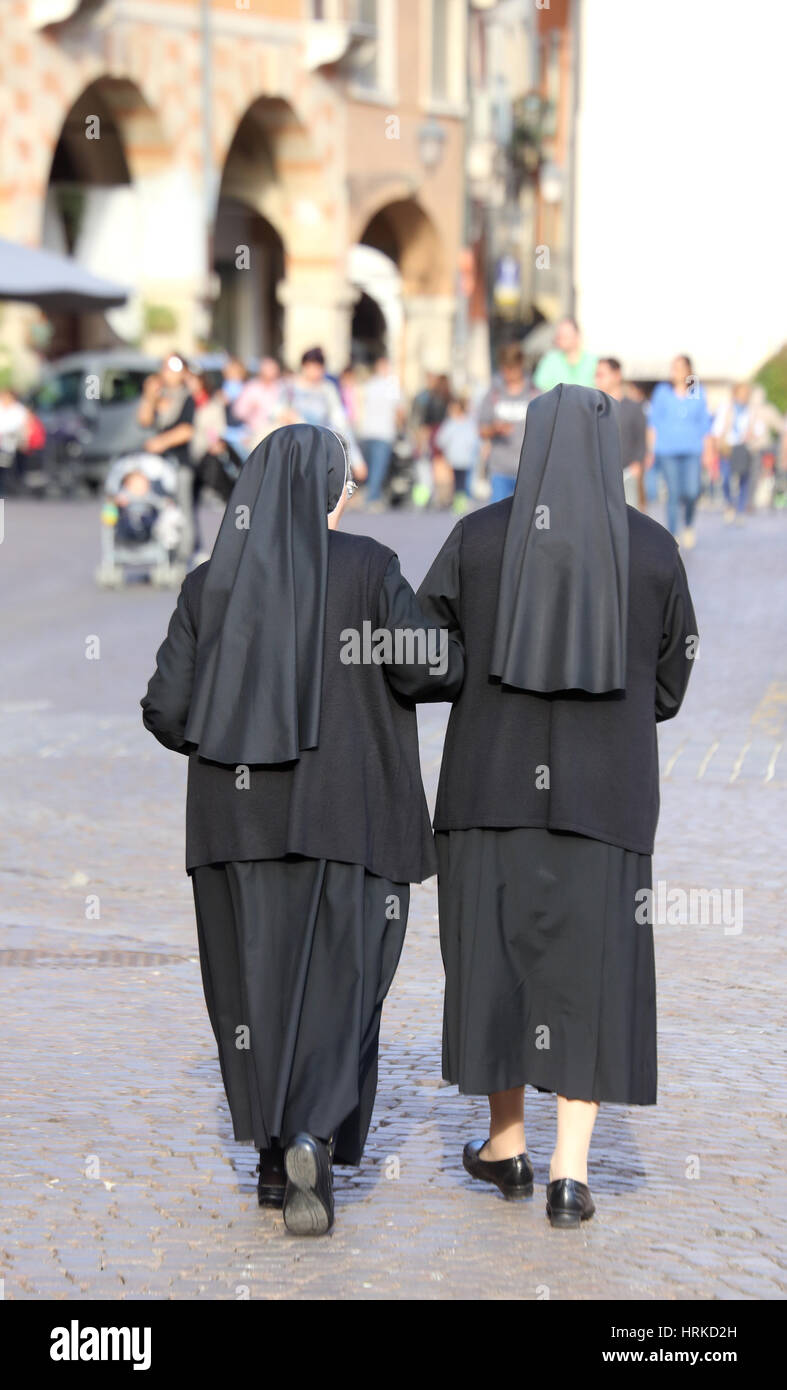 Deux religieuses noirs avec de longues robes et un voile pour couvrir les cheveux ils marchent à travers les rues de la ville Banque D'Images