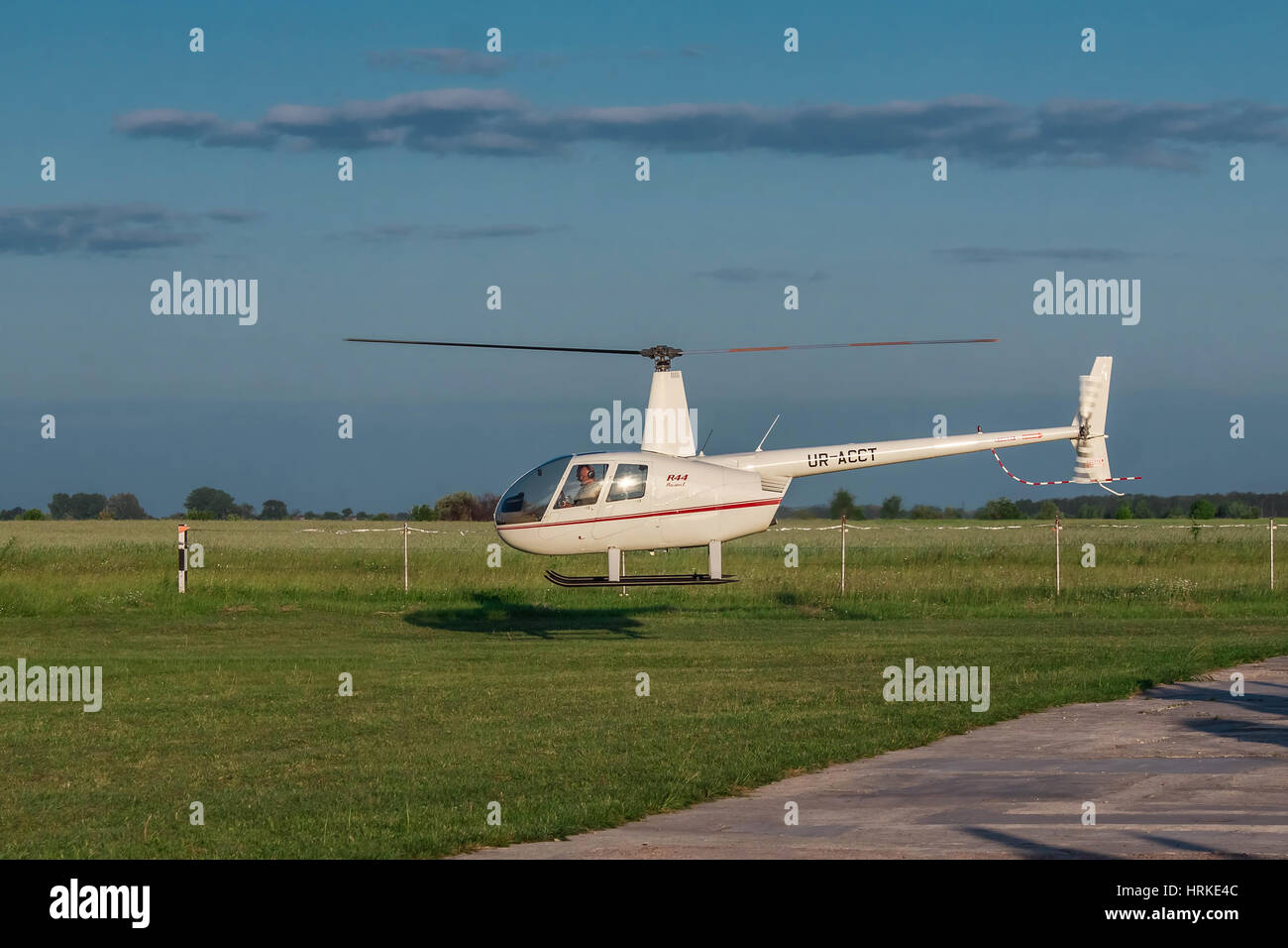 Zhitomir, Ukraine - 25 mai 2012 : Robinson R-44 à l'atterrissage de l'hélicoptère léger sur le coucher du soleil Banque D'Images