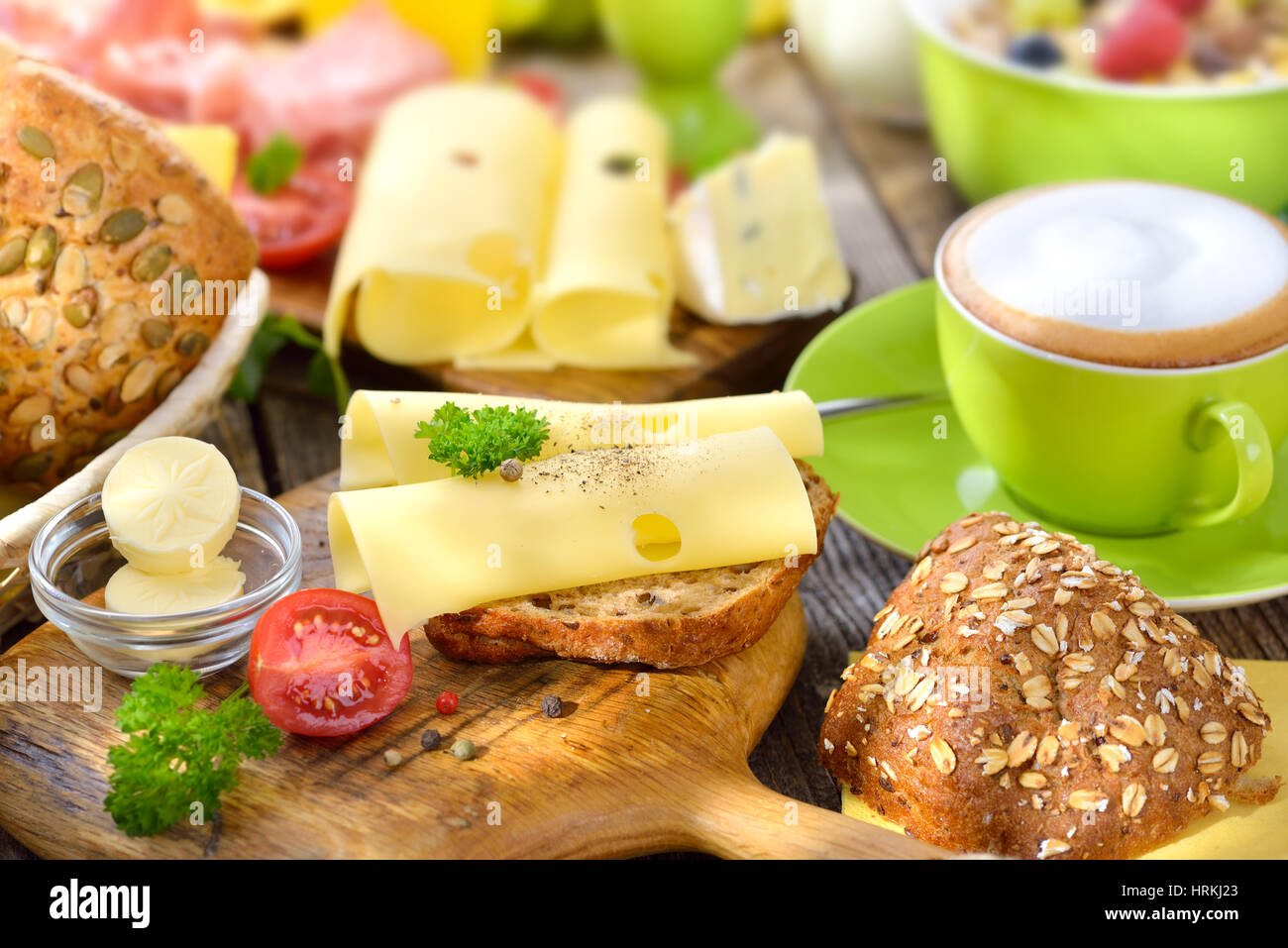 Copieux petit déjeuner avec une tasse de Cappuccino, rouleaux de fromage et un grand choix de nourriture Banque D'Images