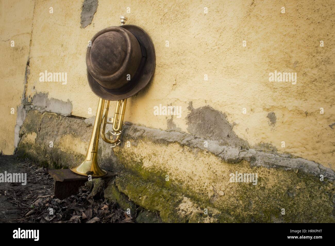 Ancienne trompette usé contre grungy wall avec pork pie hat top style Banque D'Images