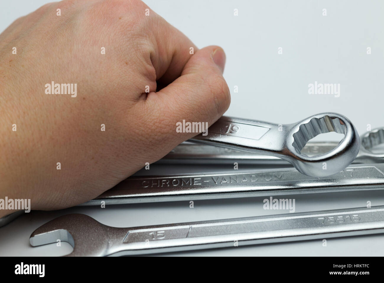 Main tenant un anneau de clés plates sur un fond blanc. Banque D'Images