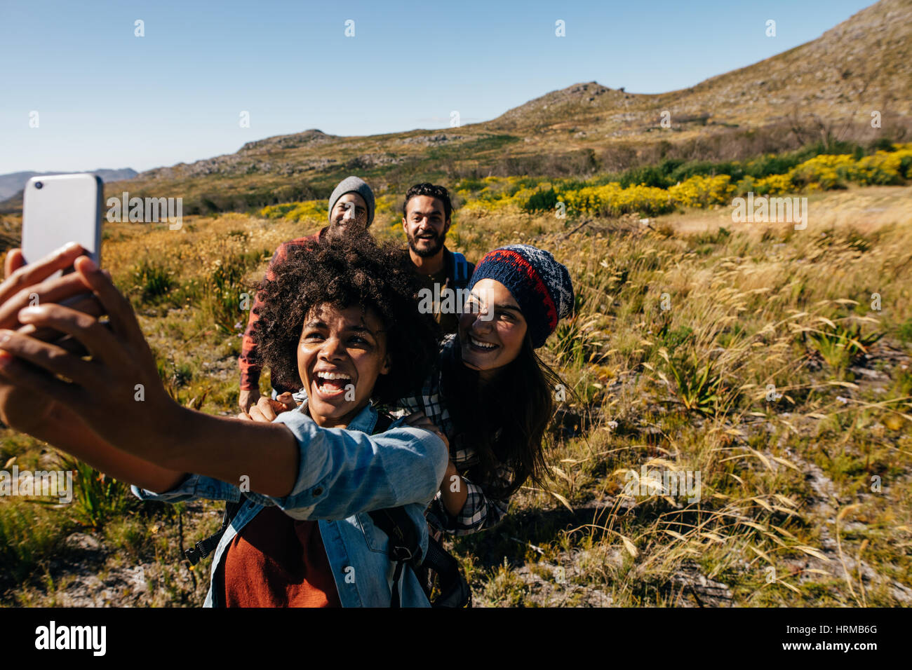 Groupe d'amis pour prendre pied en selfies campagne. Les jeunes randonnées en pays taking self portrait avec téléphone mobile. Banque D'Images
