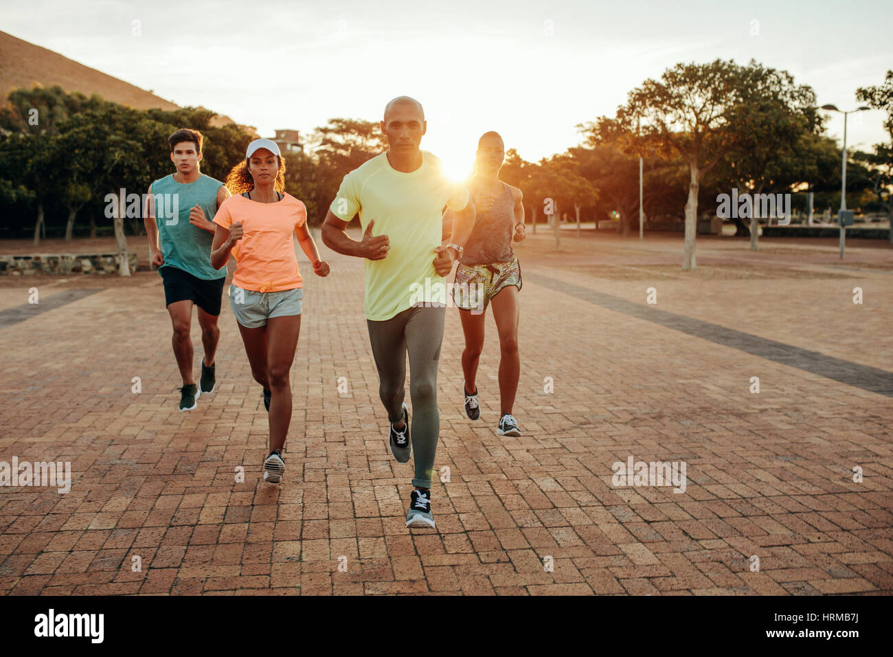 Portrait de jeunes coureurs sur le chemin du parc. En groupe à l'extérieur en soirée. Banque D'Images