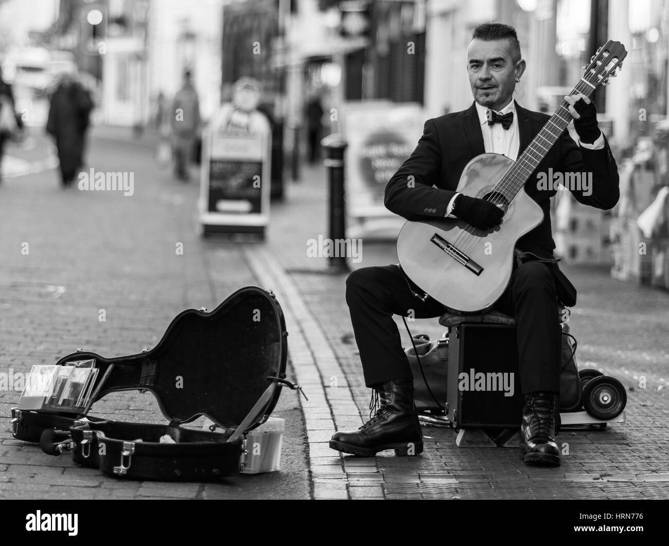 Une smart habillée musicien ambulant dans les rues de Grande-Bretagne Banque D'Images