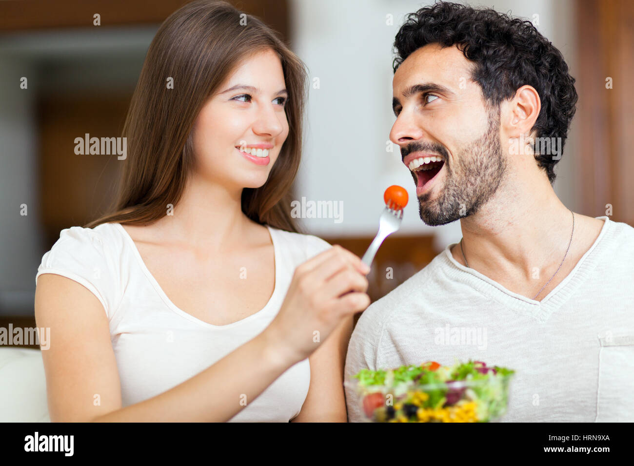 Couple eating salad sur le canapé Banque D'Images