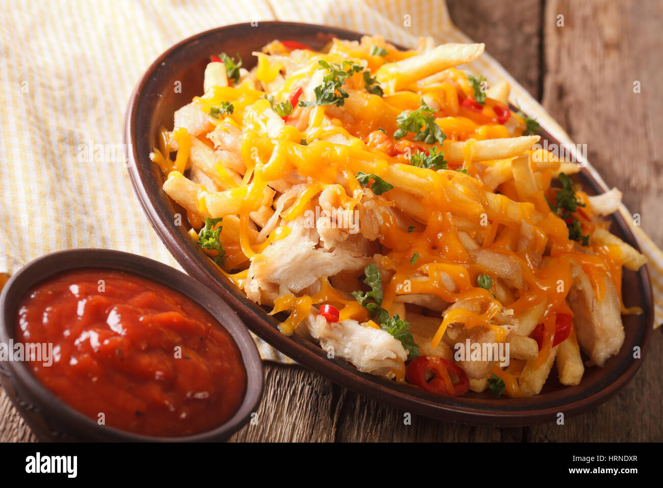 Restauration rapide américaine : Des frites avec du fromage cheddar, le piment et le poulet sur une plaque horizontale. Banque D'Images