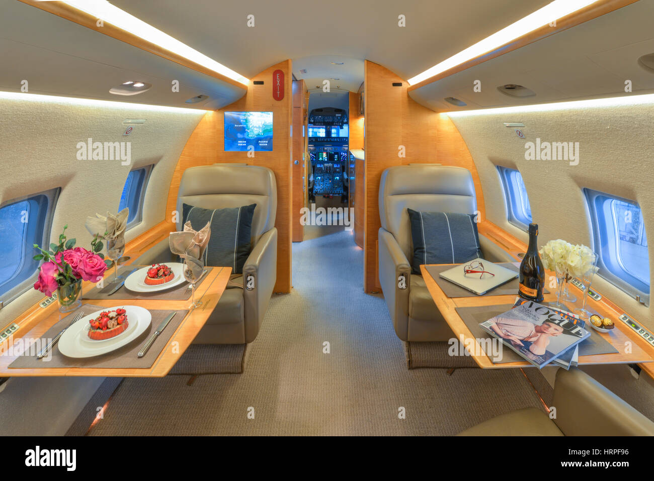 Vue de l'intérieur de Bombardier Challenger CL-604 executive jet, avec sa propre table avec la nourriture, plaqué à la recherche vers le poste de pilotage Banque D'Images