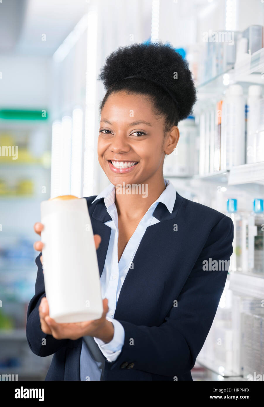 Portrait of happy businesswoman présentation bouteille en pharmacie Banque D'Images