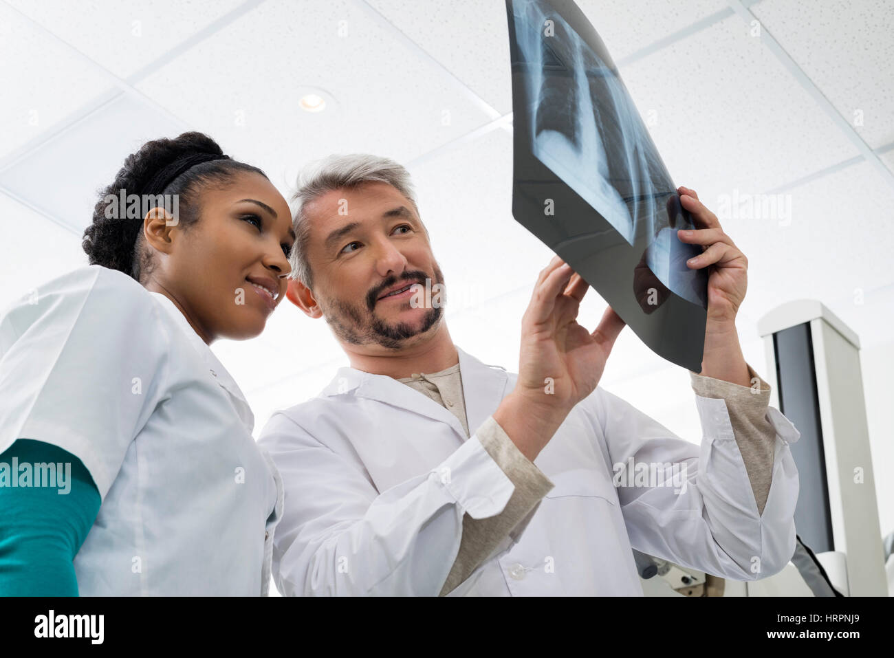 Portrait de l'homme et de la femme les radiologues l'analyse de la radiographie du thorax en salle d'examen Banque D'Images