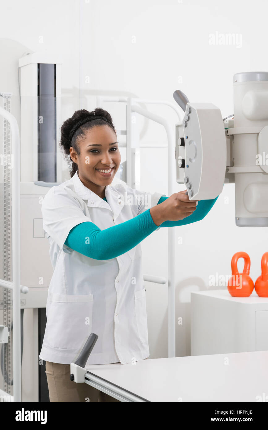Portrait de jeune femme médecin la machine à rayons x d'exploitation en salle d'examen Banque D'Images